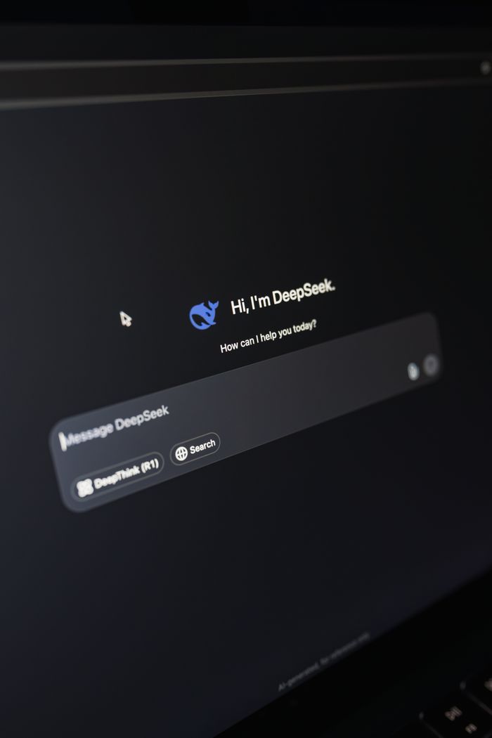 services-01 Close-up of a laptop displaying an AI interface with a chatbot prompt in dark mode.